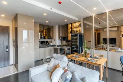 Modern open-plan living room and kitchen with sleek design and cozy dining area.