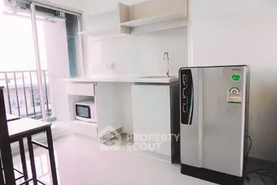 Modern kitchen with sleek fridge and microwave, bright balcony view, perfect for urban living.
