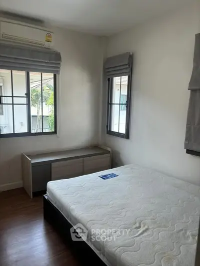 Cozy bedroom with natural light and modern furnishings in a serene residential setting.