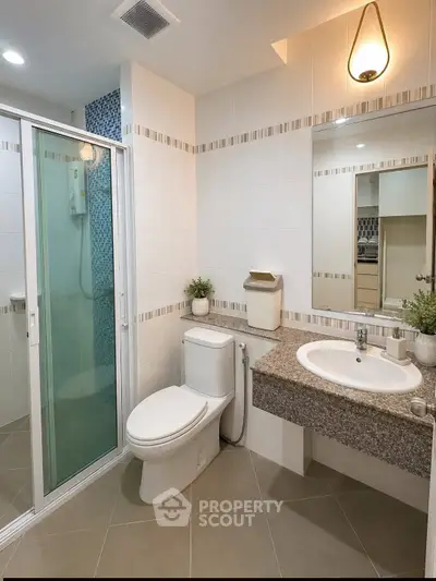 Modern bathroom with sleek shower, elegant sink, and stylish lighting in a contemporary home.