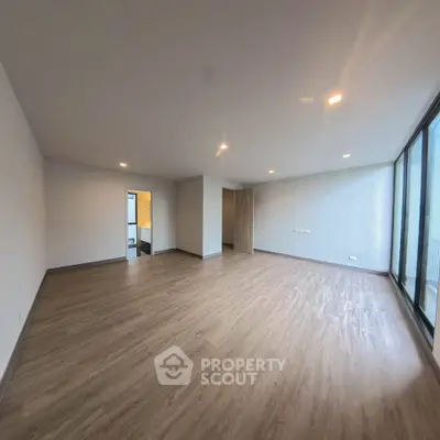 Spacious modern living room with large windows and wooden flooring