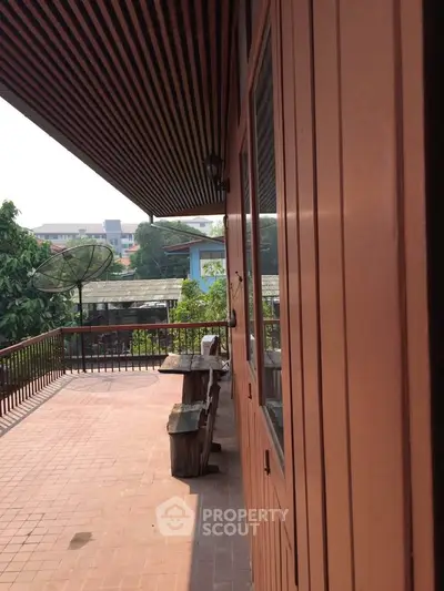 Charming balcony with rustic wooden furniture and city view, perfect for relaxation.