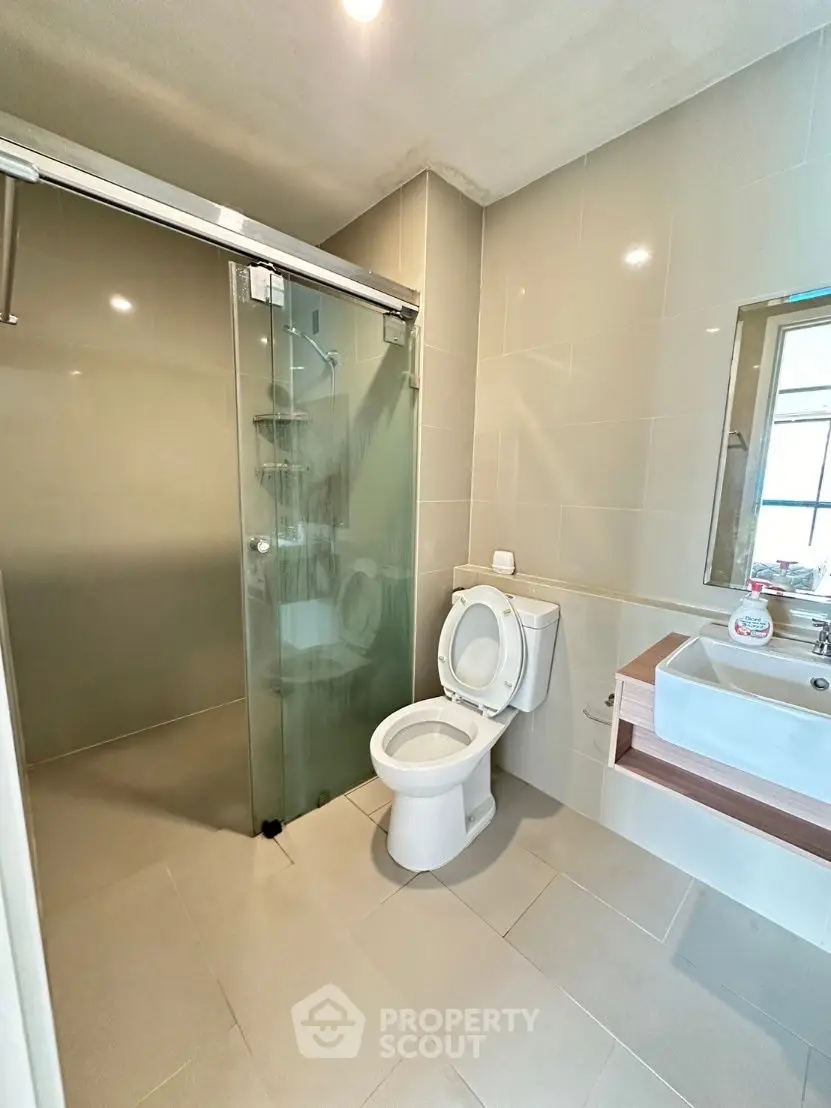 Modern bathroom with glass shower and sleek fixtures in a contemporary home.