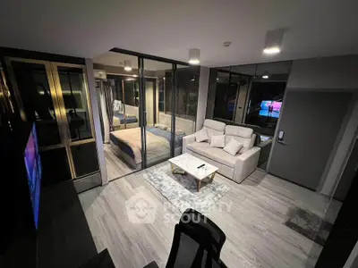 Modern open-plan living room with glass partition and cozy bedroom
