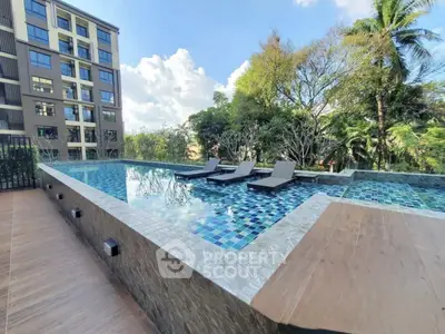Luxurious rooftop pool with sun loungers and scenic views in modern apartment complex.