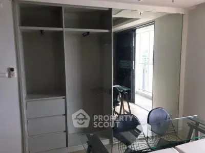 Modern apartment interior with glass dining table and built-in wardrobe near balcony.