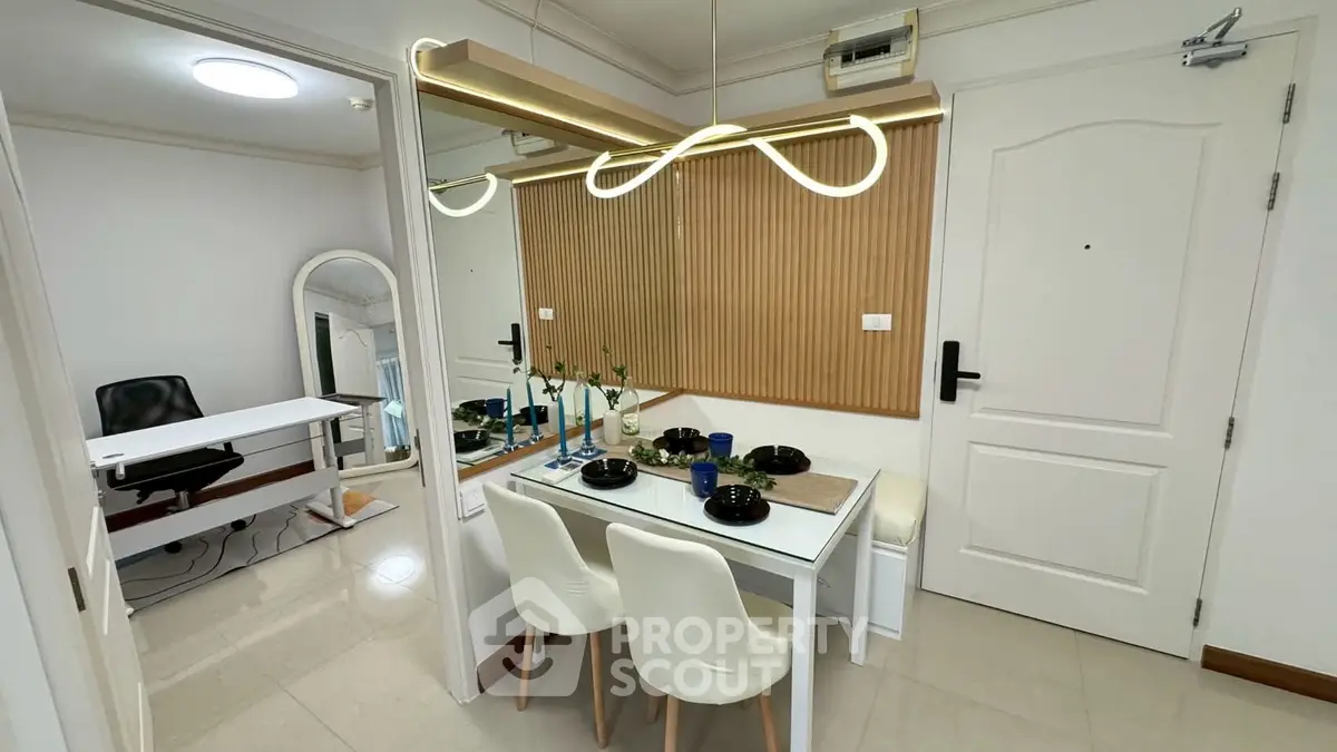 Modern dining area with stylish lighting and mirror accent wall