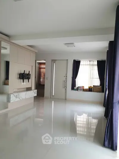Spacious modern living room with glossy floors and large windows for natural light.