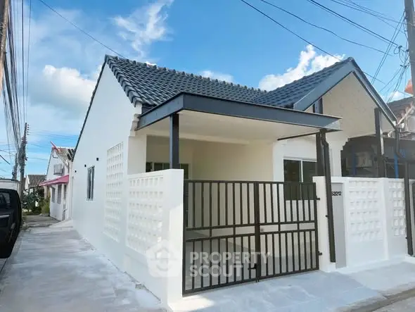 Charming single-story house with modern gate and tiled roof in a serene neighborhood.