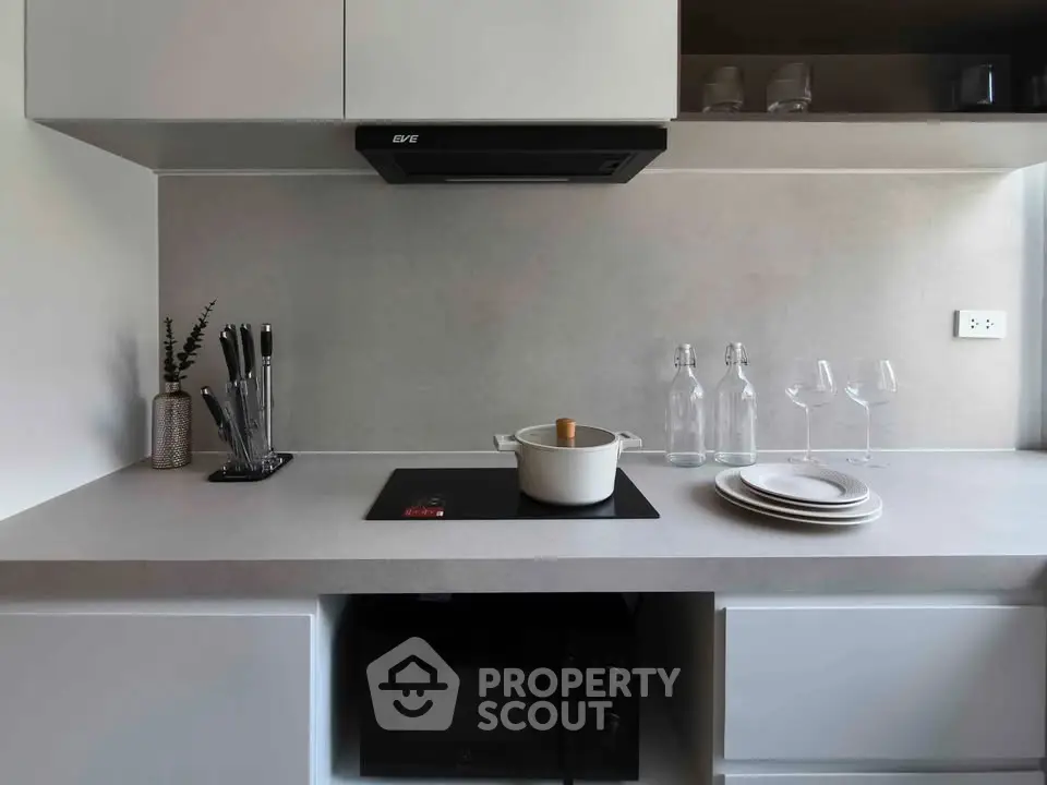 Modern kitchen with sleek design, featuring induction cooktop and minimalist decor.