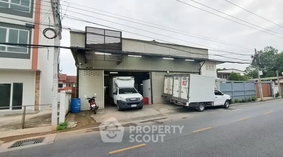 Commercial property with loading dock and trucks, ideal for logistics or storage business.