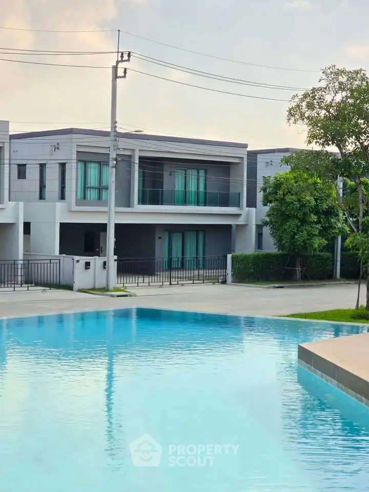 Modern townhouse with pool view, featuring sleek architecture and lush greenery, perfect for luxurious living.