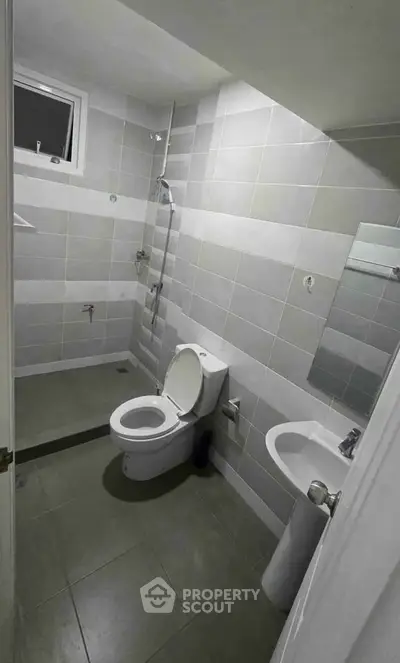 Modern bathroom with sleek tiles and contemporary fixtures in a real estate property.