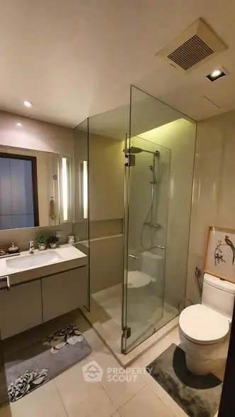 Modern bathroom with glass shower and sleek fixtures in a contemporary home.