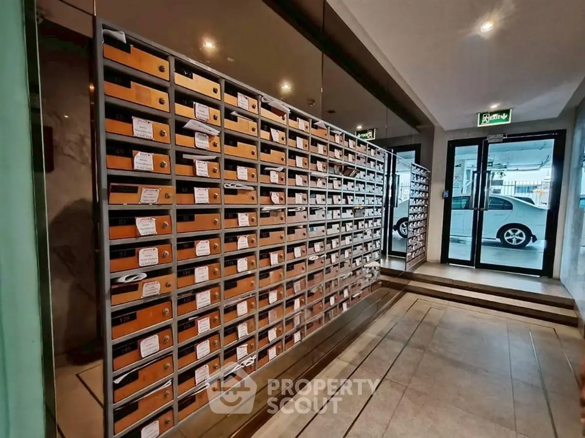 Modern apartment building entrance with mailboxes and secure parking access.