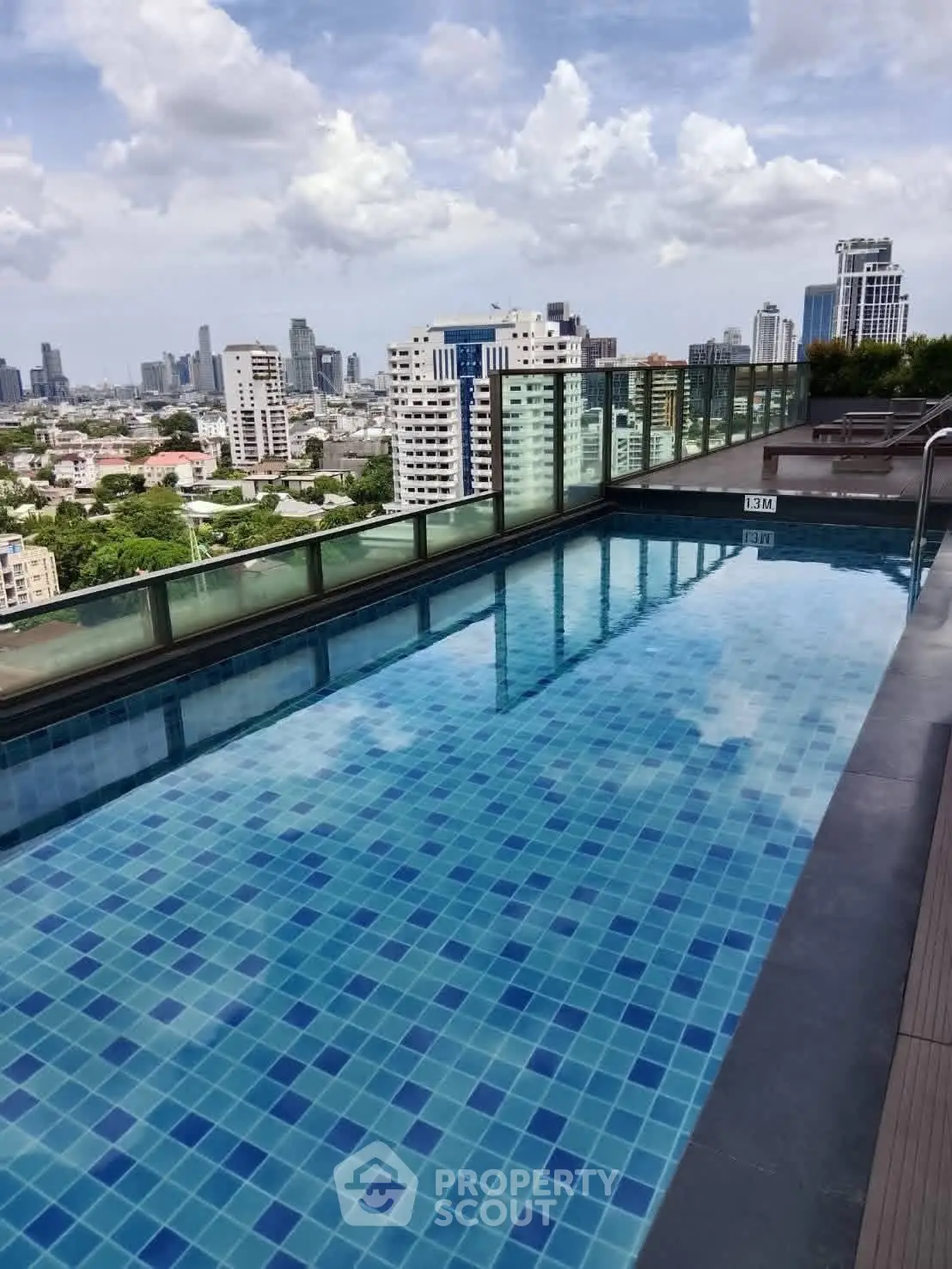 Stunning rooftop pool with panoramic city views in a luxury high-rise building.