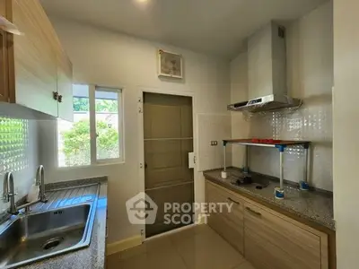Modern kitchen with granite countertops and stainless steel range hood in a cozy home setting.
