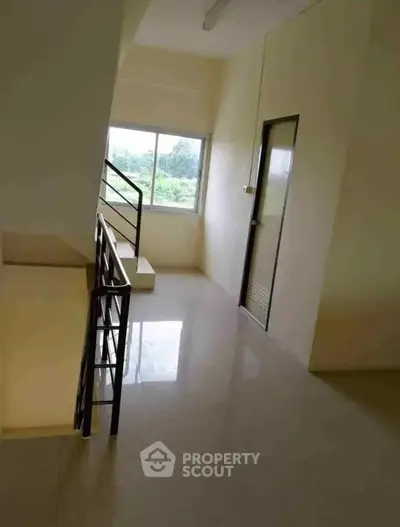 Bright hallway with window view and modern railing, perfect for natural light lovers.