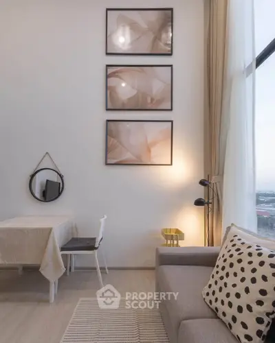 Modern living room with stylish decor and large window offering natural light.