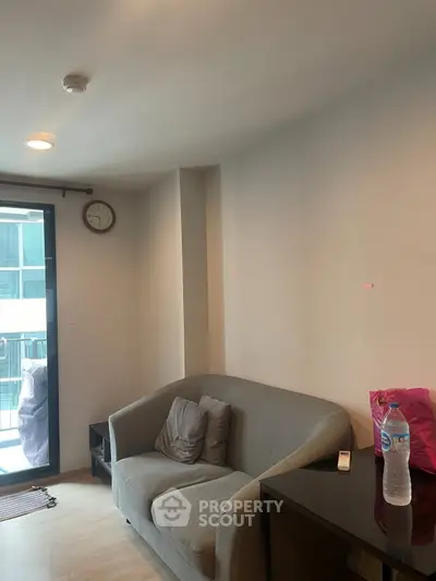 Cozy living room with modern sofa and balcony view in urban apartment