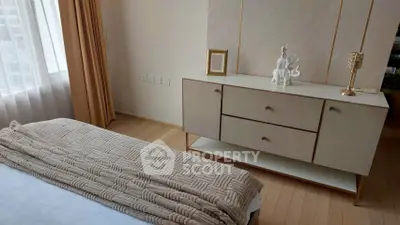 Elegant bedroom with stylish dresser and cozy bedding in modern apartment