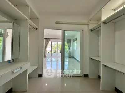 Spacious walk-in closet with sliding glass door leading to bright living area
