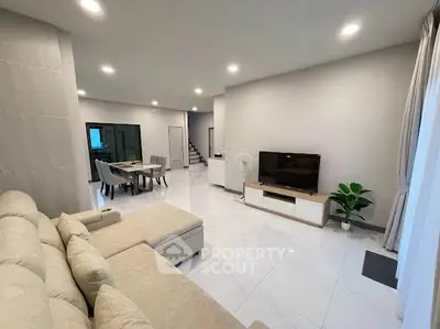 Spacious modern living room with elegant dining area and cozy seating, perfect for family gatherings.