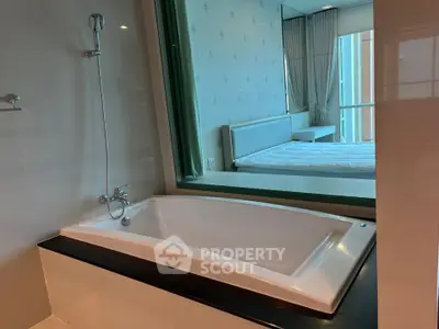 Luxurious bathroom with modern bathtub and view into a stylish bedroom, perfect for relaxation.