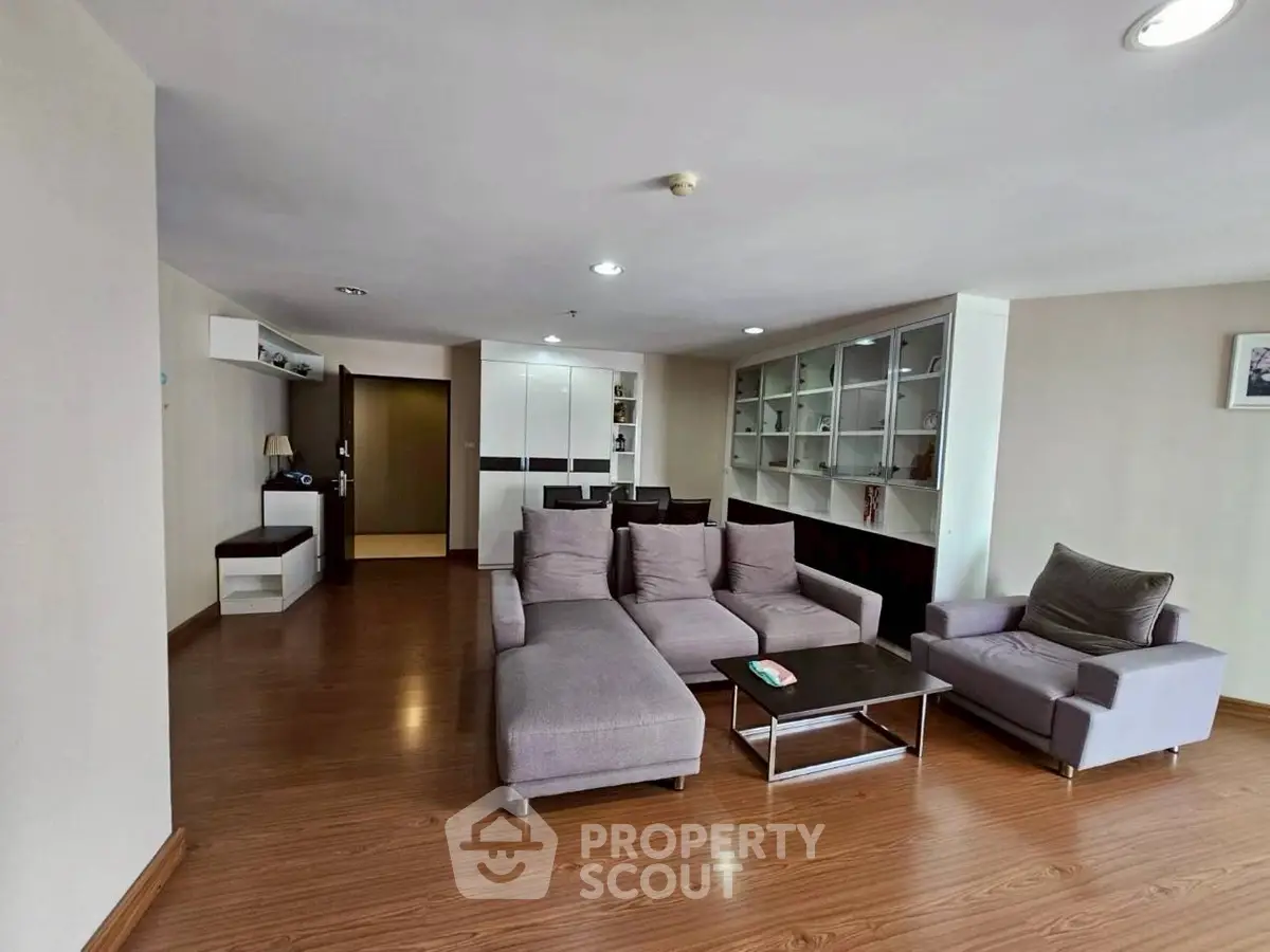 Spacious modern living room with stylish gray furniture and wooden flooring, perfect for relaxation and entertainment.