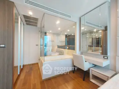 Luxurious bedroom with glass-enclosed bathtub and elegant vanity area