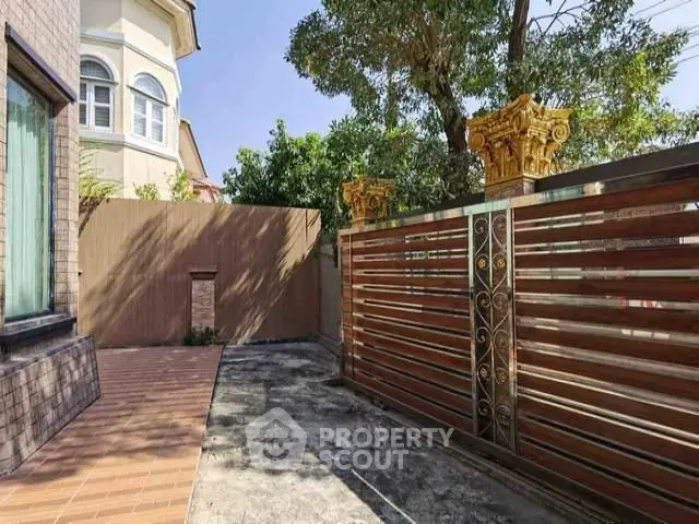 Elegant gated entrance with ornate design and spacious driveway