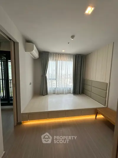 Modern bedroom with elevated platform and city view, featuring sleek design and ambient lighting.