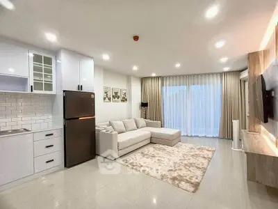 Modern open-layout living room with sleek kitchen and cozy sofa, perfect for contemporary living.