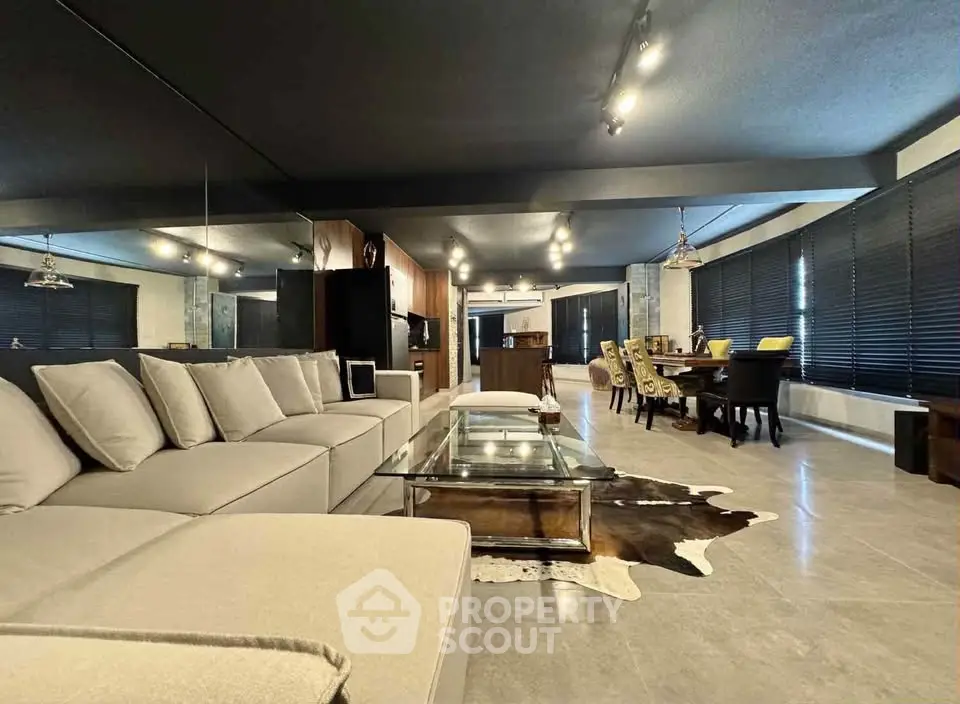 Spacious modern living room with open layout, featuring elegant dining area and stylish decor.