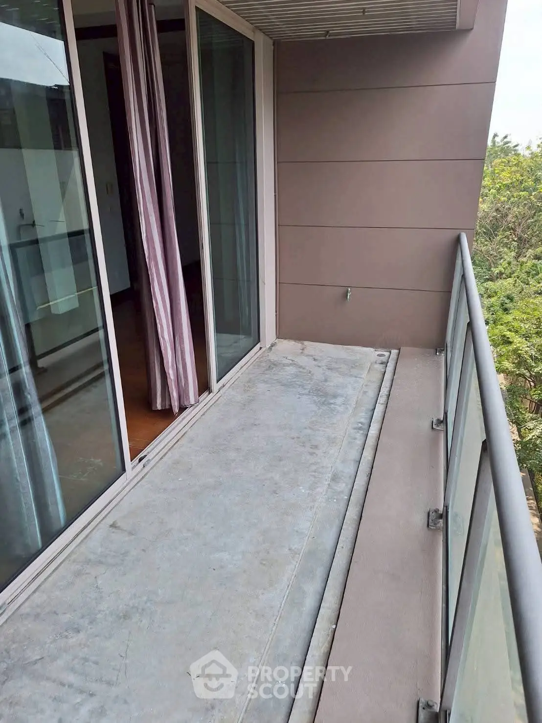 Spacious balcony with glass railing and sliding doors, perfect for relaxation and enjoying the view.
