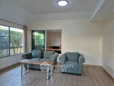 Spacious living room with modern furniture and large window view