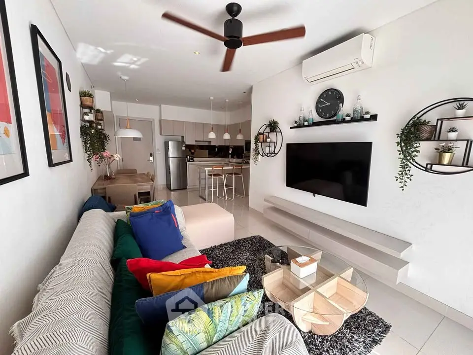 Stylish modern living room with open kitchen, vibrant decor, and ceiling fan, perfect for contemporary living.