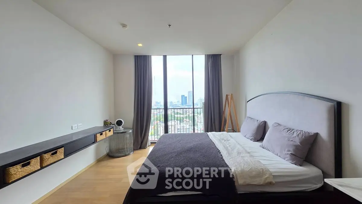Spacious bedroom with city view, modern decor, and natural light