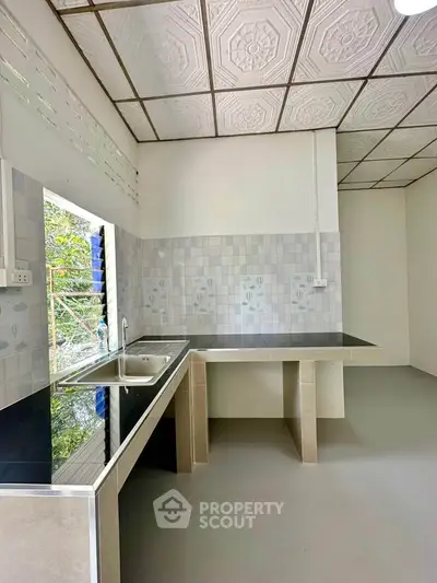 Modern kitchen with sleek countertops and stylish backsplash in a bright, airy space.