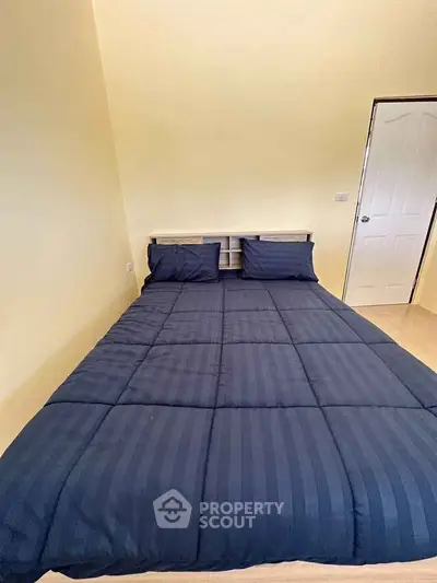 Cozy bedroom with modern design and comfortable bedding in a real estate property.