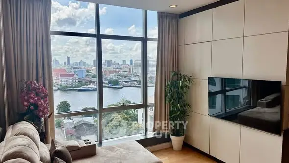 Luxurious living room with stunning city and river view, featuring modern decor and large windows.