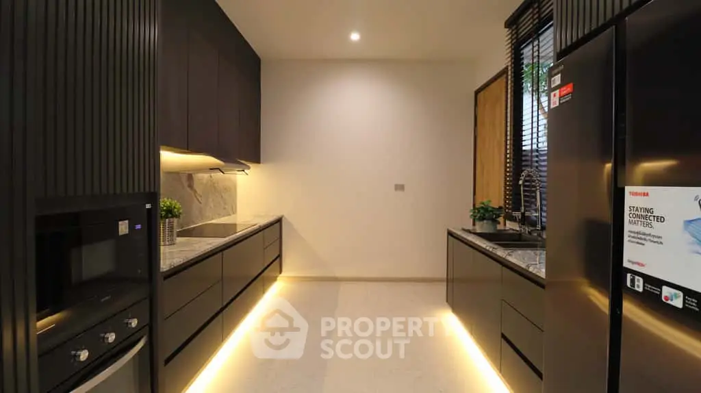 Modern kitchen with sleek cabinetry, marble countertops, and integrated appliances in a luxurious home.
