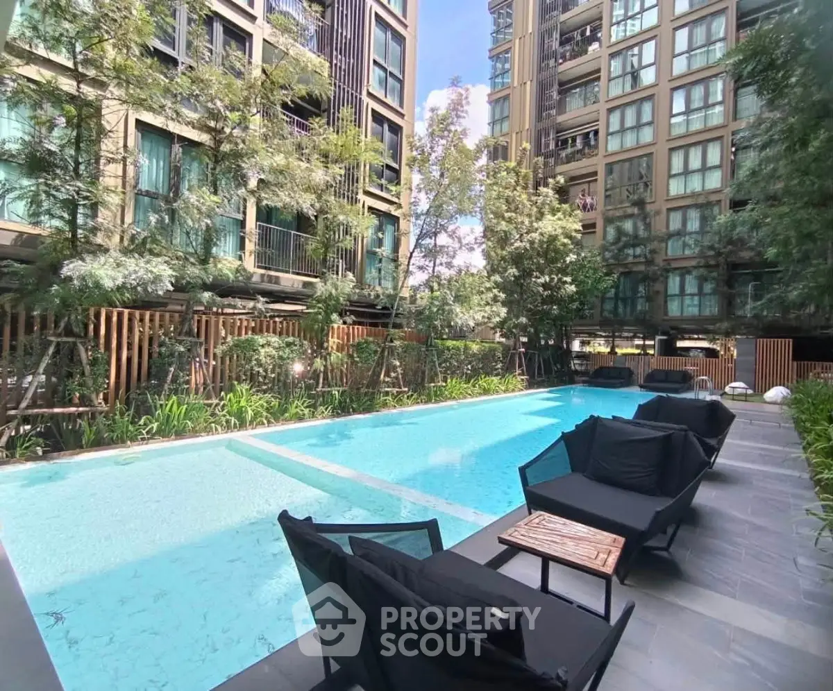 Luxurious apartment complex with modern pool and lush greenery