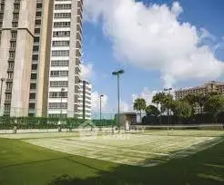 Luxurious high-rise building with tennis court and lush greenery
