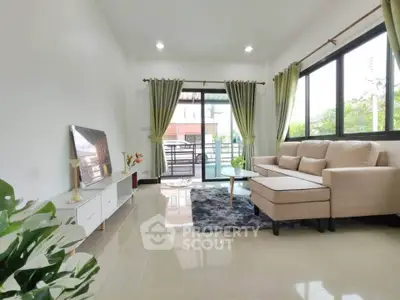 Bright and airy living room with modern decor and large windows opening to a balcony.