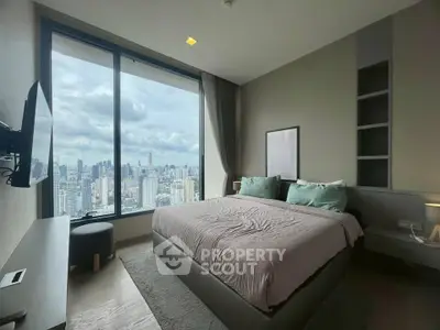 Luxurious bedroom with stunning city view from floor-to-ceiling windows in a high-rise apartment.