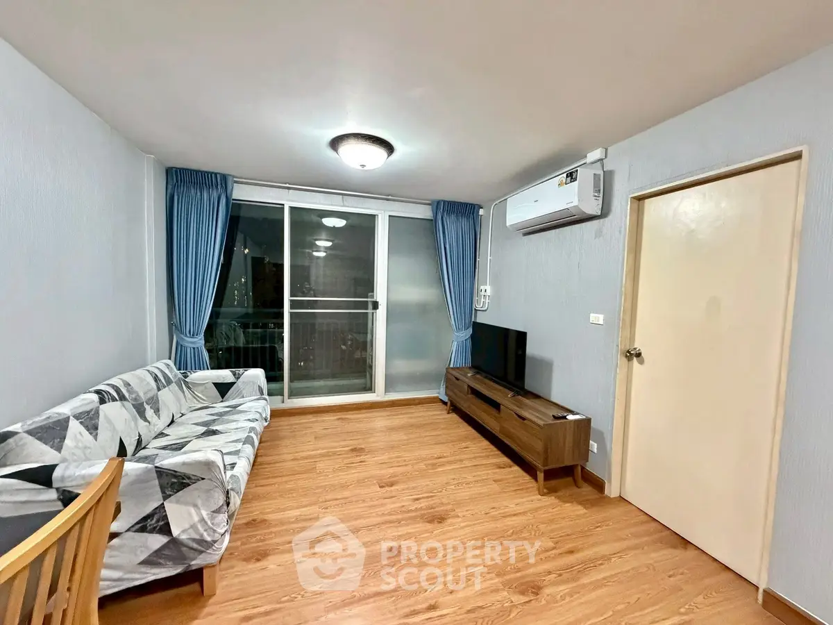 Spacious living room with modern decor and large window for natural light.
