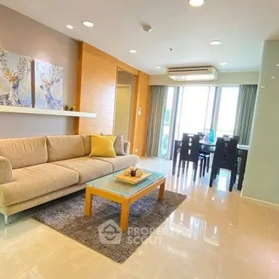 Spacious modern living room with elegant decor and dining area, featuring large windows for natural light.