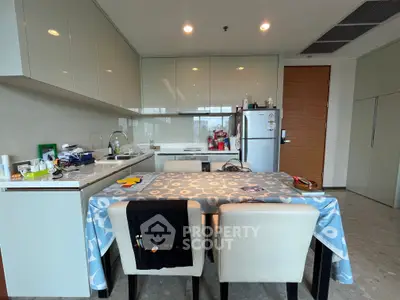 Modern kitchen with sleek cabinetry and dining area in a stylish apartment
