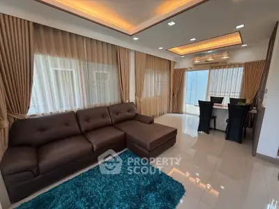 Luxurious living room with elegant curtains, plush sofa, and modern dining area.